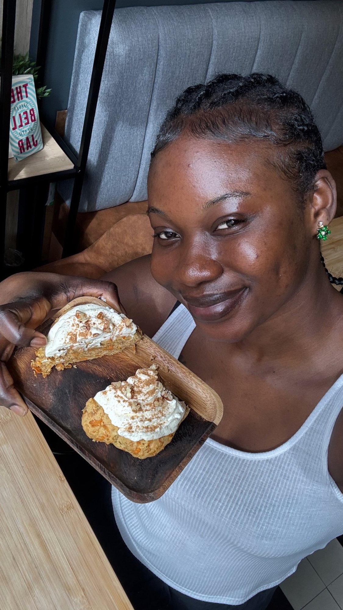 A woman smiling with a cream-filled pastry at Omo Omo
