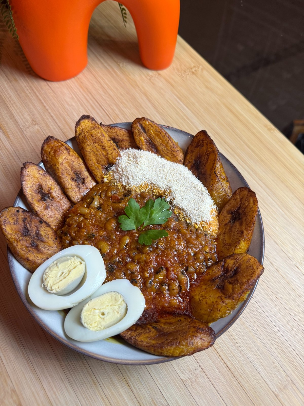 Bean stew with fried plantain, boiled egg and a white side