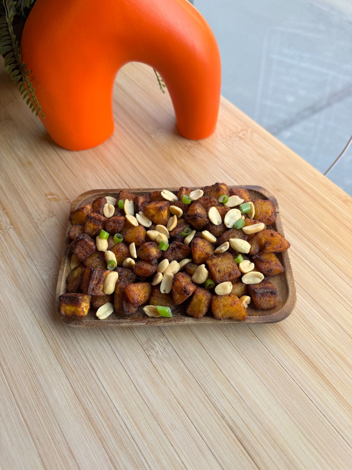 Golden fried bites garnished with sliced spring onions and red pepper
